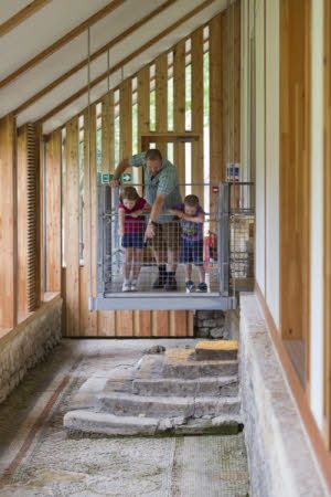 Visitors looking over the rail of the suspended walkway above the mosaic floor in the West Range. National Trust Images/James Dobson.